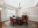 Virtually staged dining room with hardwood floors, wainscoting, and a modern chandelier at 1808 Mill Chase Ln, Waxhaw, NC 28173