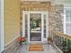 A close-up view of the front door, framed by stone and sidelights, invites guests into the home at 1808 Mill Chase Ln, Waxhaw, NC 28173