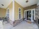 Inviting front porch with stone accents, chairs, and a 'Welcome' mat leads to a charming home's entrance at 1808 Mill Chase Ln, Waxhaw, NC 28173