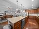 Open kitchen design with large island featuring granite countertops, wood cabinets, and stainless steel appliances at 1808 Mill Chase Ln, Waxhaw, NC 28173