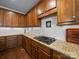 Close up view of kitchen features granite countertops, wood cabinets, white backsplash and gas cooktop at 1808 Mill Chase Ln, Waxhaw, NC 28173