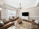 Cozy living room features leather seating, a detailed rug, and a large window providing ample natural light at 1808 Mill Chase Ln, Waxhaw, NC 28173