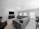 Spacious living room with large sofa, carpet, and tv mounted above cabinet at 1808 Mill Chase Ln, Waxhaw, NC 28173