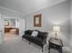 Sitting room adjacent to bathroom includes a seating area with a dark sofa and mirror at 1808 Mill Chase Ln, Waxhaw, NC 28173