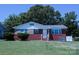 Classic brick home with landscaped yard, white railings, and charming architectural details at 1926 Eastway Dr, Charlotte, NC 28205