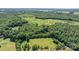An elevated view captures a lush estate with a serene pool area bordered by verdant woods and grassy land at 200 Vista Pointe Dr, Stony Point, NC 28678