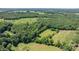 Sweeping aerial view reveals verdant surroundings, highlighting a private estate enveloped by rich wooded areas at 200 Vista Pointe Dr, Stony Point, NC 28678