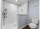 Tiled walk-in shower with glass surround, contrasting nicely with blue walls and a modern toilet at 200 Vista Pointe Dr, Stony Point, NC 28678