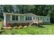 Charming home features a quaint front deck, well-maintained lawn, and mature trees for privacy at 200 Vista Pointe Dr, Stony Point, NC 28678