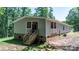 Charming exterior elevation displays a quaint porch and access steps, nestled in lush, wooded greenery at 200 Vista Pointe Dr, Stony Point, NC 28678