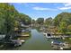Picturesque aerial view of a tranquil lake with docks and boats, surrounded by lush trees at 21212 Rio Oro Dr, Cornelius, NC 28031