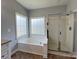 Bright bathroom showcasing a soaking tub under a window and a glass-enclosed shower at 2609 Lamp Post Ln, Kannapolis, NC 28081