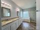 Spacious bathroom featuring double vanity, granite countertop, soaking tub, and glass-enclosed shower at 2609 Lamp Post Ln, Kannapolis, NC 28081
