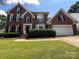 Charming brick home with black shutters, well-manicured lawn, and attached two-car garage at 2609 Lamp Post Ln, Kannapolis, NC 28081