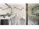 A bright bathroom featuring dual sinks, a soaking tub, and a glass enclosed shower at 3109 Buckleigh Dr, Charlotte, NC 28215