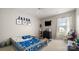 bedroom with vibrant blue accents, a window, and a small entertainment setup at 3109 Buckleigh Dr, Charlotte, NC 28215