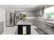 Spacious kitchen with gray cabinets, granite countertops, stainless steel appliances, and a center island at 3109 Buckleigh Dr, Charlotte, NC 28215