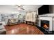 Cozy living room featuring a fireplace, hardwood floors, a comfortable sofa, and natural light at 3109 Buckleigh Dr, Charlotte, NC 28215