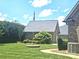 Beautifully landscaped backyard, including a well-maintained lawn, flowerbeds, and an American Flag at 323 Wendover Dr, Locust, NC 28097