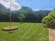 Lush, green lawn and manicured landscaping create a serene backyard, perfect for outdoor activities at 323 Wendover Dr, Locust, NC 28097