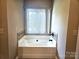 Bright bathroom featuring a soaking tub with tile surround at 323 Wendover Dr, Locust, NC 28097