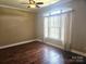 Bright bedroom featuring a ceiling fan, a large window, and beautiful wood floors at 323 Wendover Dr, Locust, NC 28097
