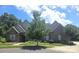 Charming brick home featuring a lush green lawn, beautiful landscaping, and a peaceful residential setting at 323 Wendover Dr, Locust, NC 28097
