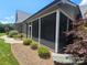 Charming screened porch on a brick home with manicured landscaping for relaxed outdoor living at 323 Wendover Dr, Locust, NC 28097
