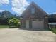 Spacious detached two-car garage featuring durable brick construction and ample driveway parking at 323 Wendover Dr, Locust, NC 28097