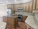 Open kitchen featuring stainless steel appliances, granite countertops and custom wood cabinets at 323 Wendover Dr, Locust, NC 28097