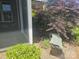 Mature landscaping surrounds the screened porch, enhancing the property's curb appeal and privacy at 323 Wendover Dr, Locust, NC 28097