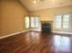 Inviting living room featuring a fireplace, hardwood floors, and ample natural light from large windows at 323 Wendover Dr, Locust, NC 28097