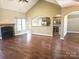 Stylish living room with fireplace, hardwood floors, and a seamless transition into the kitchen area at 323 Wendover Dr, Locust, NC 28097