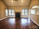 Spacious living area with a fireplace, hardwood floors, and large windows offering plenty of light at 323 Wendover Dr, Locust, NC 28097