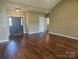 Open-concept living room with hardwood floors, a front door view, and neutral wall color at 323 Wendover Dr, Locust, NC 28097
