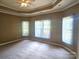 Spacious main bedroom features a tray ceiling, plush carpet, and lots of natural light at 323 Wendover Dr, Locust, NC 28097