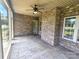 Charming outdoor space with brick walls, a stone floor, ceiling fan, and a view of the well-maintained yard at 323 Wendover Dr, Locust, NC 28097