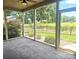 Relaxing screened porch with stone floors, a ceiling fan, and views of the manicured backyard at 323 Wendover Dr, Locust, NC 28097