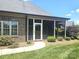 Inviting screened porch offers a relaxing outdoor living space with lush landscaping and manicured lawn at 323 Wendover Dr, Locust, NC 28097