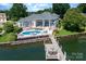 Aerial view of a luxurious house with a dock, pool, and lake access at 3394 Governors Island Dr, Denver, NC 28037
