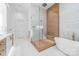 Modern bathroom featuring a glass shower, soaking tub, and wood grain accent wall at 3394 Governors Island Dr, Denver, NC 28037