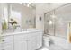 Bathroom with bright natural light, white cabinets, and a shower over tub at 3394 Governors Island Dr, Denver, NC 28037