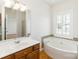 Bathroom with corner soaking tub, wood vanity, and decorative tiling accents at 3624 Ramsey Rd, Sharon, SC 29742