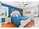 Stylish bedroom with a blue accent wall, hardwood floors, and a ceiling fan, creating a peaceful retreat at 3651 16Th Ne St, Hickory, NC 28601