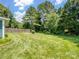 Large grassy backyard with mature trees, partial fence, and well-maintained lawn at 3720 Winterberry Nw Ct, Concord, NC 28027