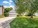 Inviting one-story home with a spacious driveway and well-maintained front yard and mature trees at 3720 Winterberry Nw Ct, Concord, NC 28027