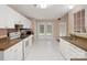 Bright kitchen with white cabinets, white appliances, and tile flooring at 3720 Winterberry Nw Ct, Concord, NC 28027