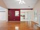 Bright living room featuring hardwood floors, an accent wall, and views into the kitchen at 3720 Winterberry Nw Ct, Concord, NC 28027