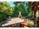 Outdoor patio featuring a hot tub, stone fireplace, seating, and beautifully landscaped surroundings for relaxing entertainment at 3889 Mattingly Dr, Hickory, NC 28602