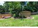 Backyard storage shed with garden bed, wood bench, and lush lawn at 3889 Mattingly Dr, Hickory, NC 28602